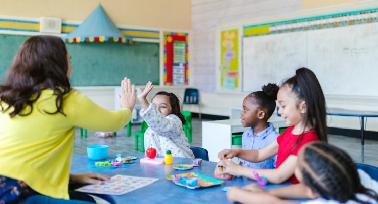 Grafika przedstawiająca zabawę nauczycielki z dziećmi.