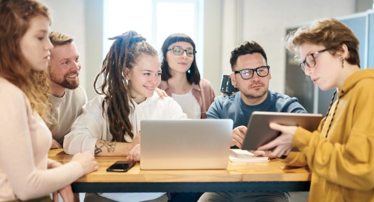 Młodzież wraz z nauczycielami pracująca podczas lekcji na laptopie i tablecie