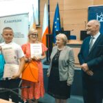 R. Kosowski, H. Cimer, prof. J.T. Duda i laureat konkursu wraz z opiekunem