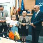 R. Kosowski, H. Cimer, prof. J.T. Duda i laureat konkursu wraz z opiekunem