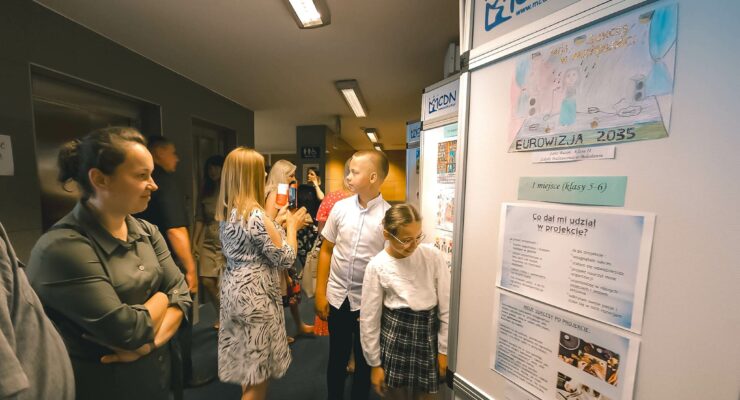 Rodzice i dzieci oglądający wystawę prac konkursowych.