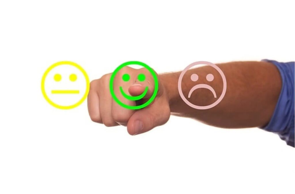 Wyciągnięta dłoń z trzema emotikonami