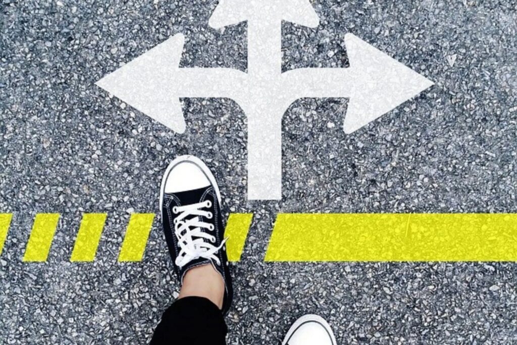 buty, znak drogowy na asfalcie