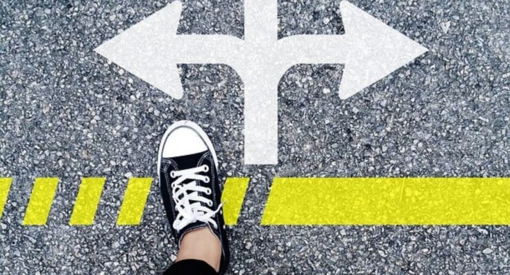 buty, znak drogowy na asfalcie