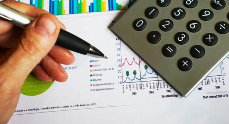 ręka z długopisem przy kalkulatorze