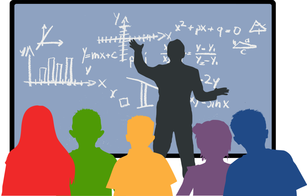 grafika przedstawia zarys postać nauczyciela przy tablicy oraz zarysy uczniów