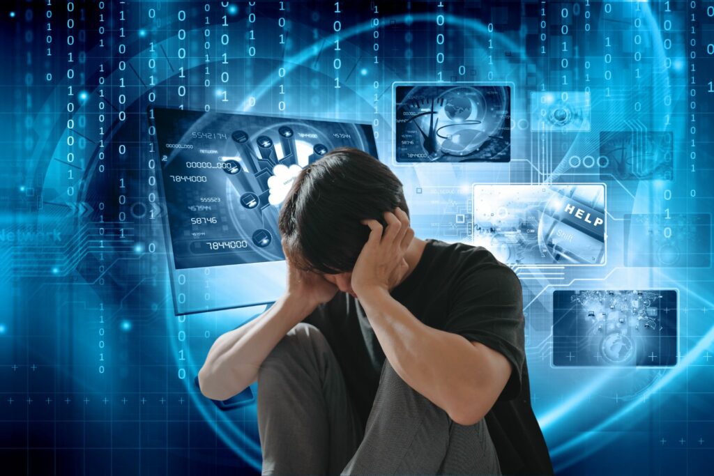 zarysy komputerów, liczb, tło niebieskie, pośrodku młody człowiek obejmujący rękami swojagłowę