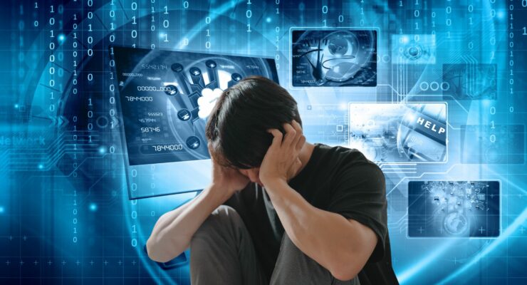 zarysy komputerów, liczb, tło niebieskie, pośrodku młody człowiek obejmujący rękami swojagłowę