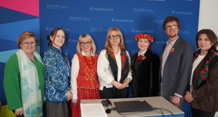 Na tle banneru MCDN: dr Małgorzata Dutka-Mucha, wicedyrektor Małopolskiego Centrum Doskonalenia Nauczycieli w Krakowie i prelegenci konferencji